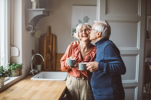 Older Couple Kissing Cheek Kitchen Tea