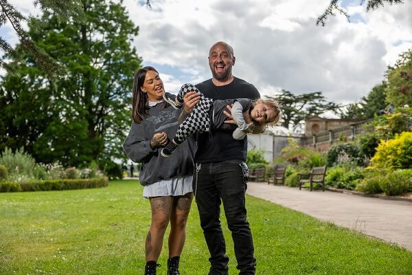 Couple Holding Child Smiling Chequered Tattoos