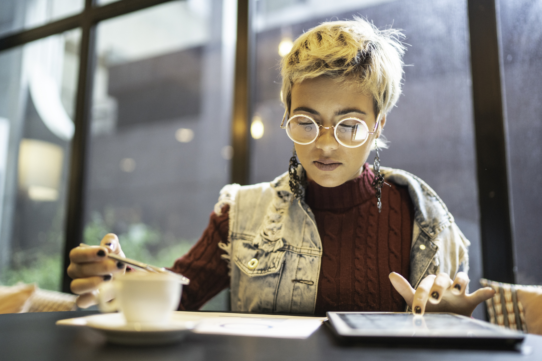 Woman wearing glasses looking coffee ipad