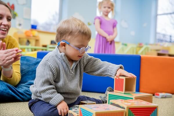 Baby Wearing Glasses Playing With Wooden Blocks