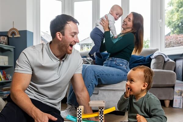 Family In Living Room Playing With Cars