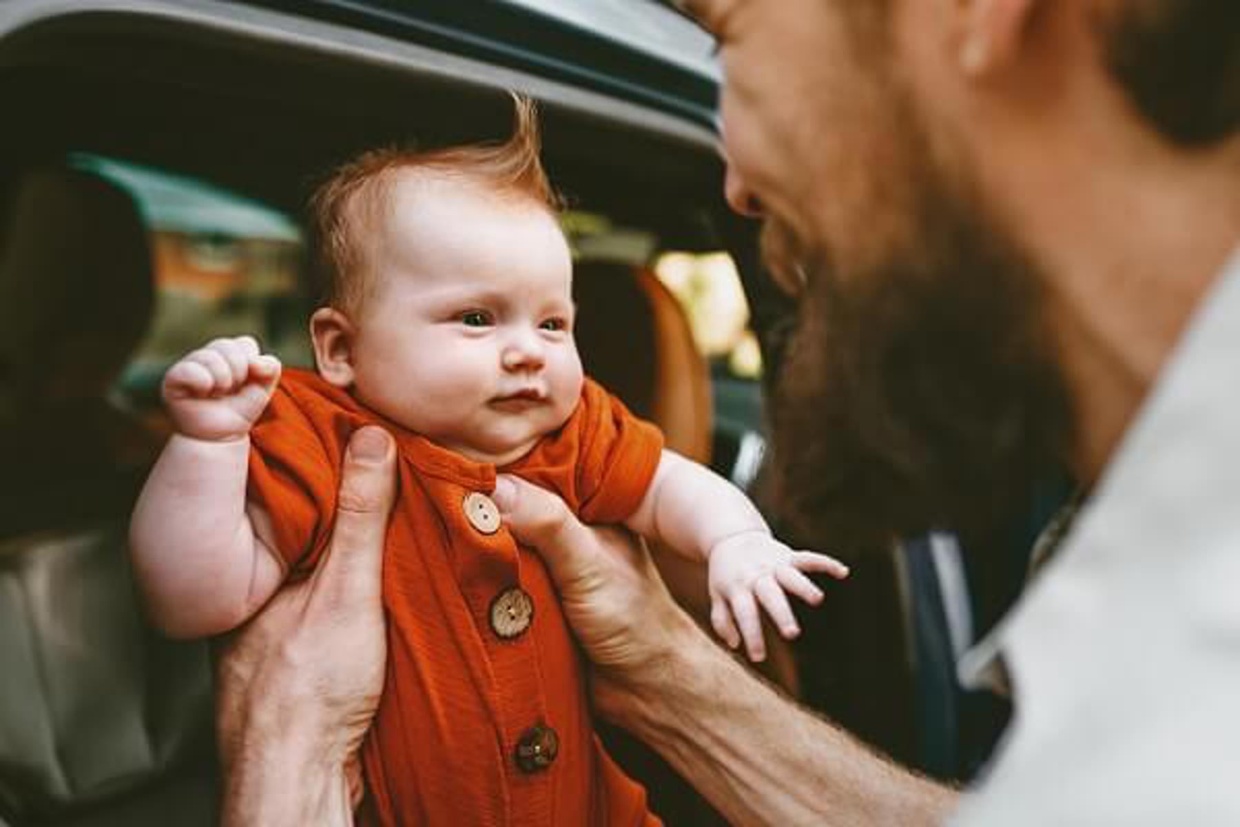 Man Holding Baby Orange Outfit