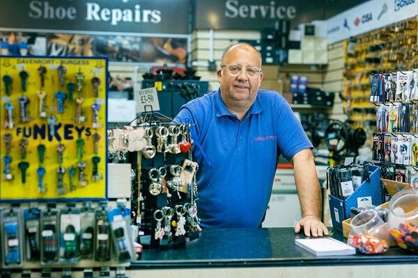 Man At Counter Of Shoe Repair Shop