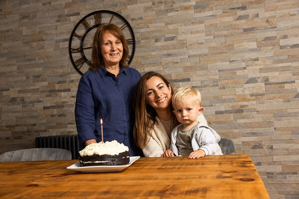 Baby Mum Grandma Looking At Camera Smiling Birthday Cake