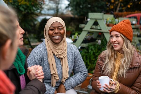 Women Sitting Outside Tea Orange Hat