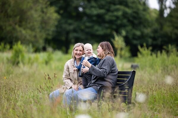 Couple Sitting On Bench With Baby