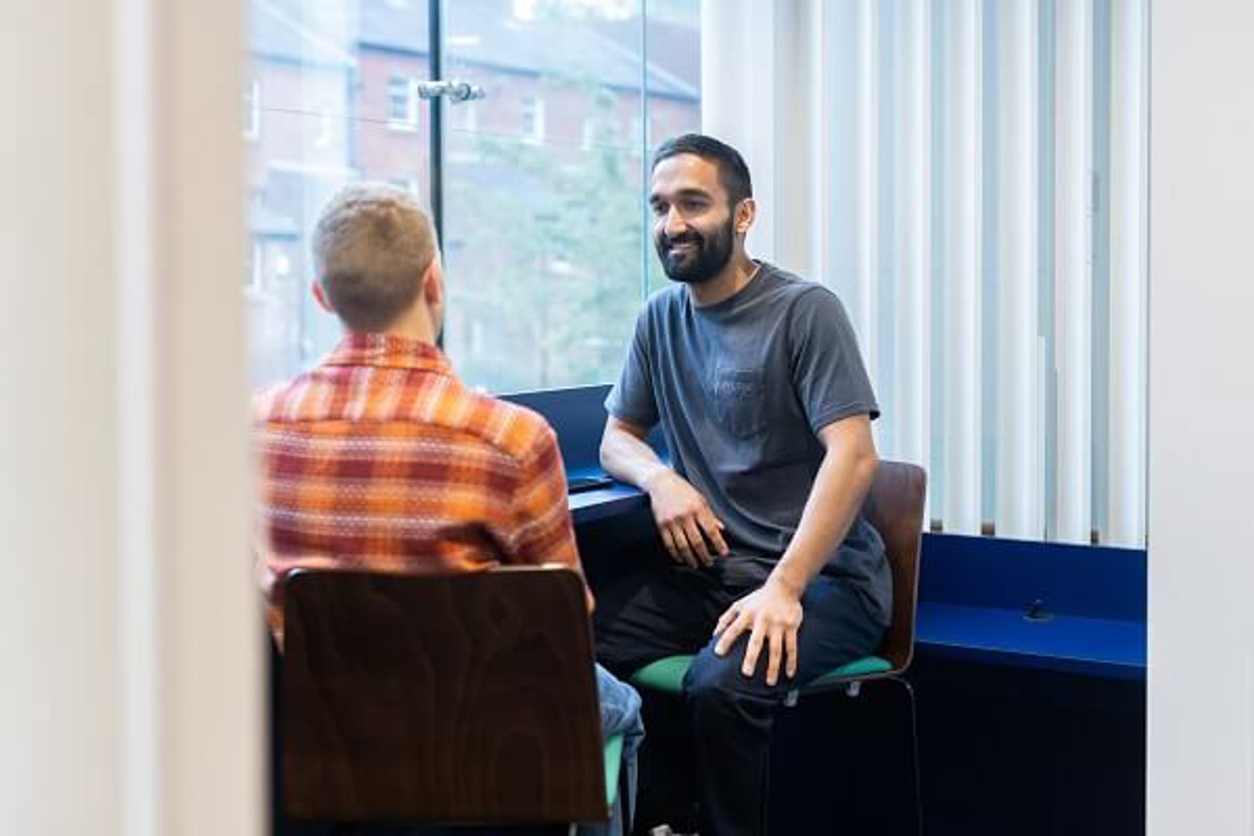 Two Colleages Talking On Chairs