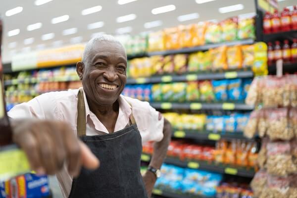 Shop Keeper Standing In Front Of Crisps