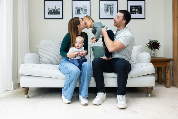 Couple With Children Kissing Baby