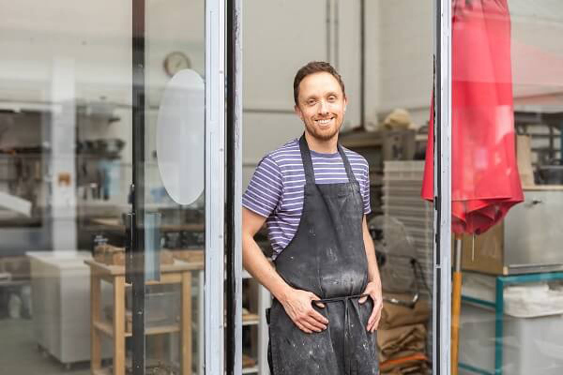 Man At Shop Door Wearing Apron