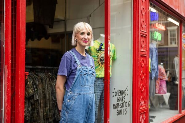 Woman In Shop Door Red Building Overalls