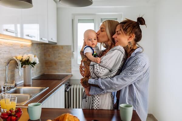 Couple In Kitchen Hugging Kissing Baby