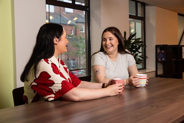 Two Colleagues Chatting Tea Red Dress