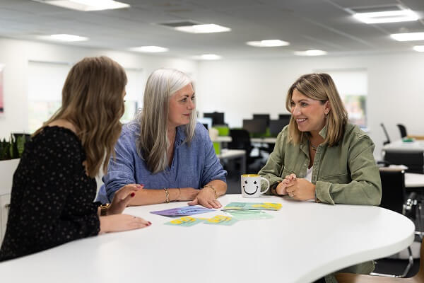 Three Colleagues At Table Talking